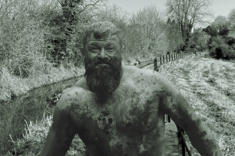 Bare-chested farmer covered in mud
