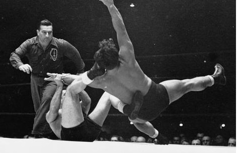 Black and White image of men a wrestling ring